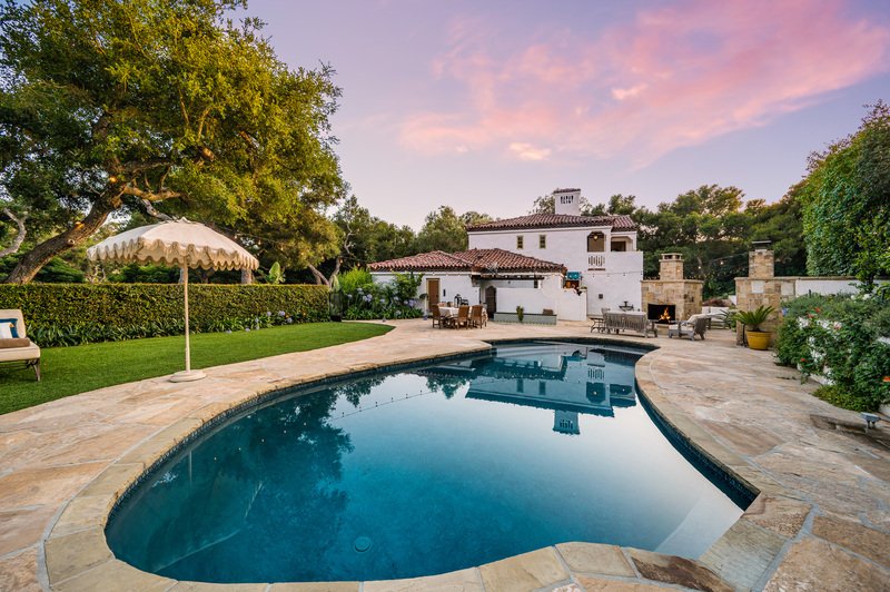 Jardin de casa con alberca y sombrillas